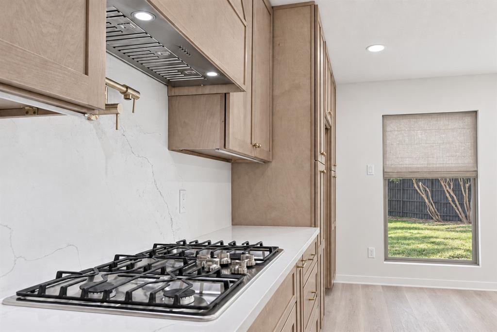 Built-in gas cooktop with stainless steel range hood will delight any Chef