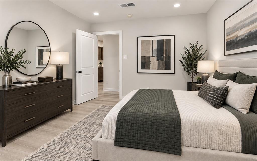 Bedroom 3 has recessed lighting illuminates the neutral wall tones and light wood-finish lpv flooring