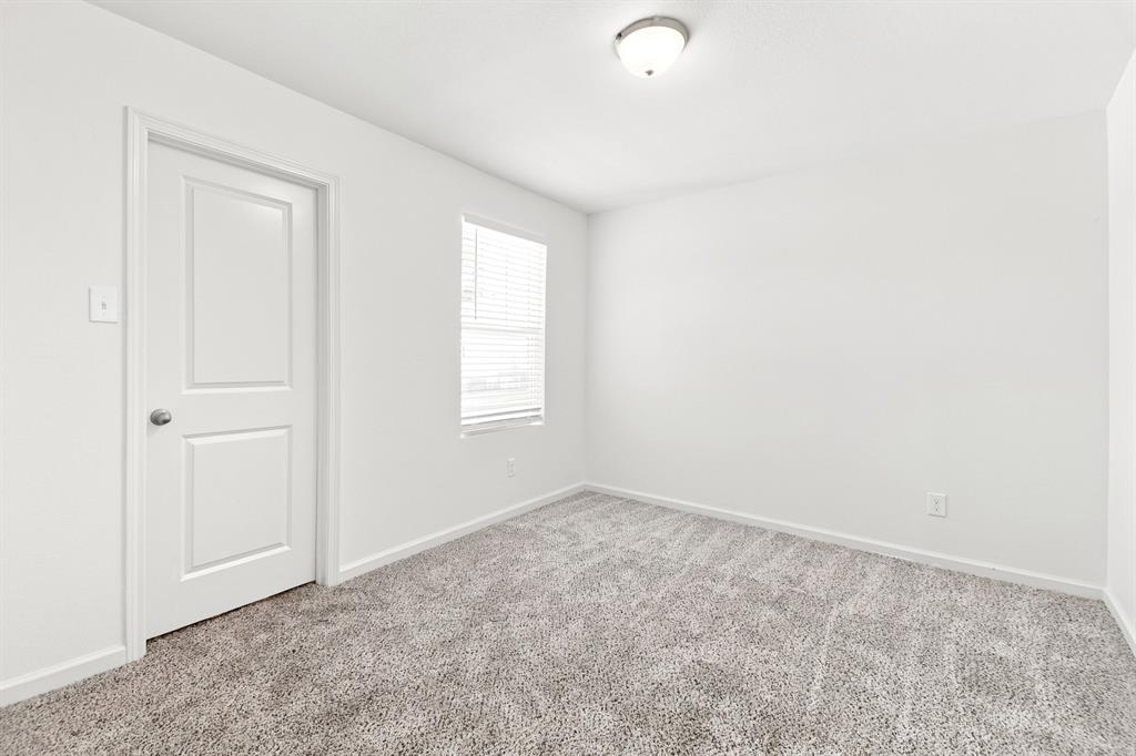 Room featuring light gray textured carpeting, white walls, and a single window with horizontal blinds Room featuring light gray textured carpeting, white walls, and a single window with horizontal blinds