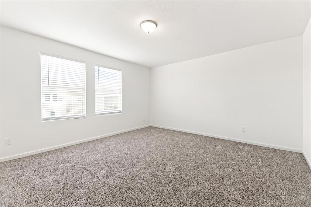 Spacious room featuring neutral carpeting and white painted walls Spacious room featuring neutral carpeting and white painted walls