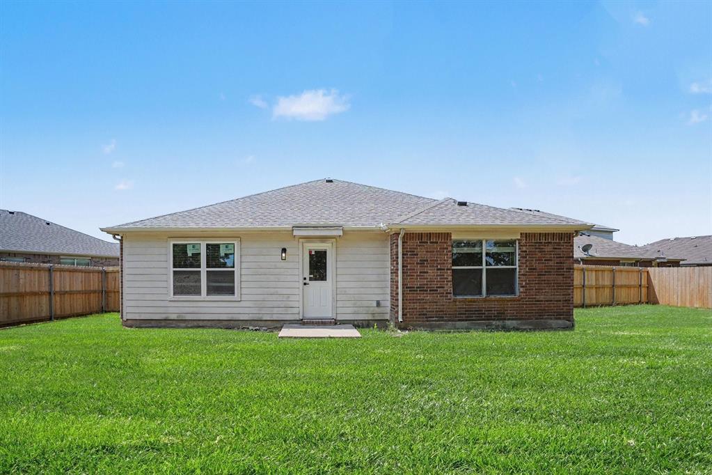 Expansive green lawn with a wood privacy fence
