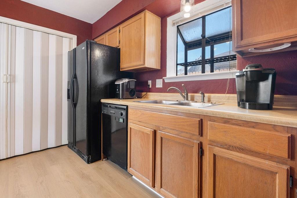 Warm burgundy walls frame this updated kitchen featuring wood-finish cabinetry, black stainless steel appliances, and wood-finish countertops Warm burgundy walls frame this updated kitchen featuring wood-finish cabinetry, black stainless steel appliances, and wood-finish countertops