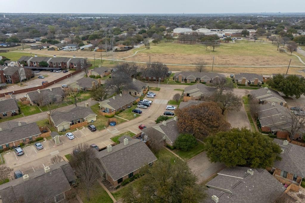 Residential community with a mix of single-story and multi-story structures, featuring paved parking areas and mature landscaping