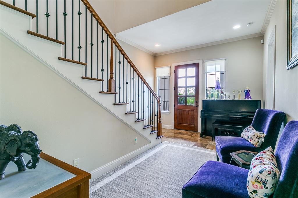 Spacious entryway featuring tile flooring and a beautifully crafted hardwood staircase.