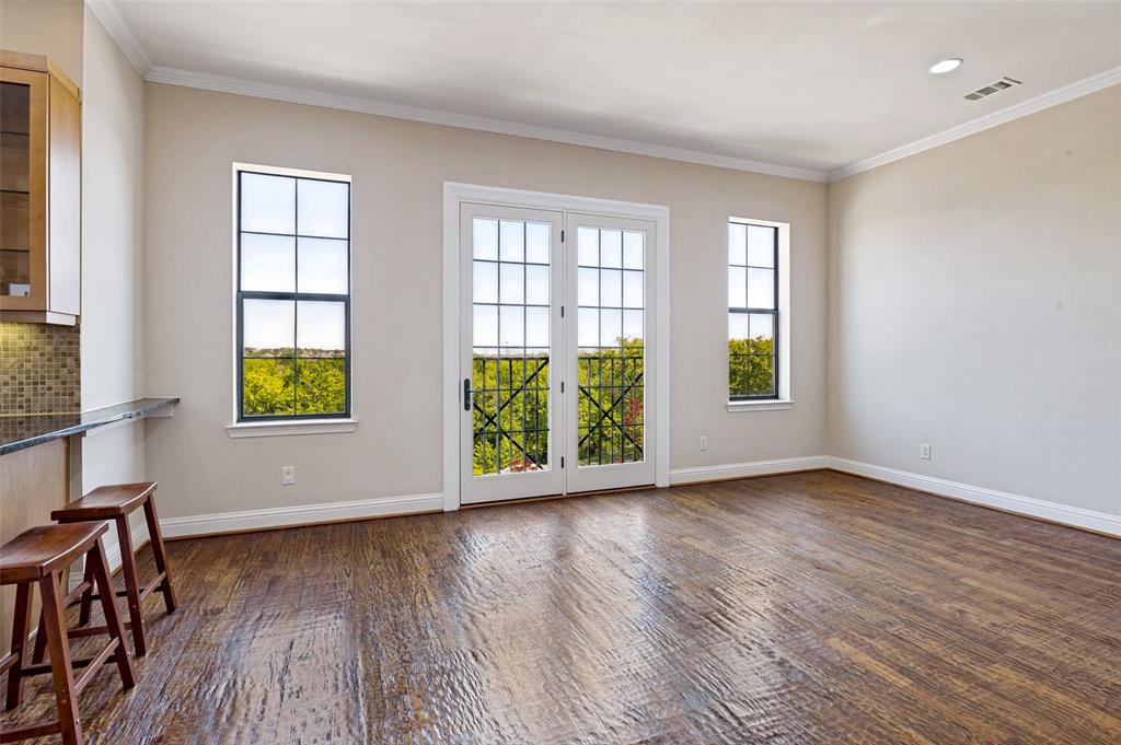 Dining room filled with natural light with windows overlooking green space.