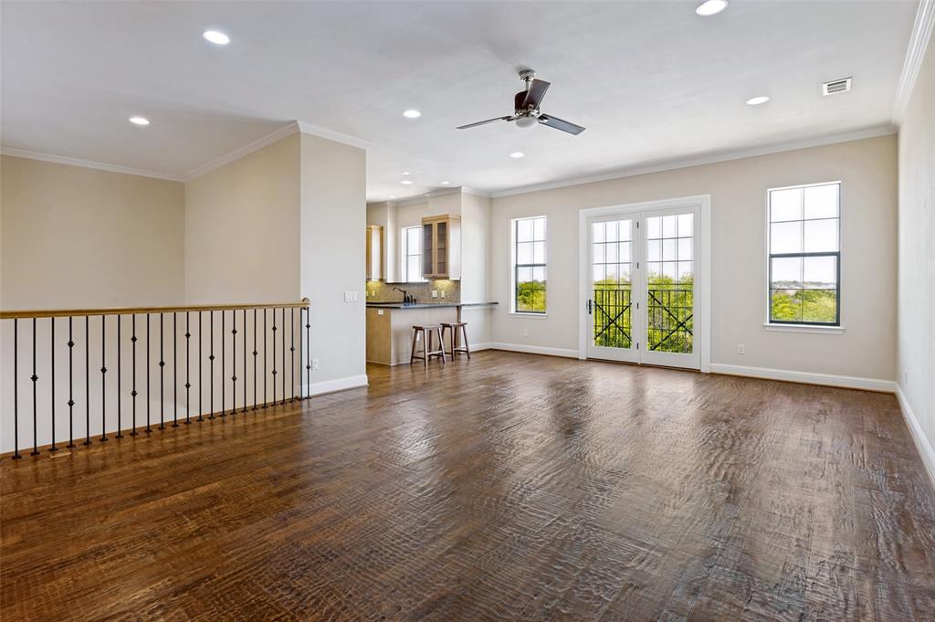Expansive living room featuring hand-scraped wood flooring, abundant natural light and a flexible layout.