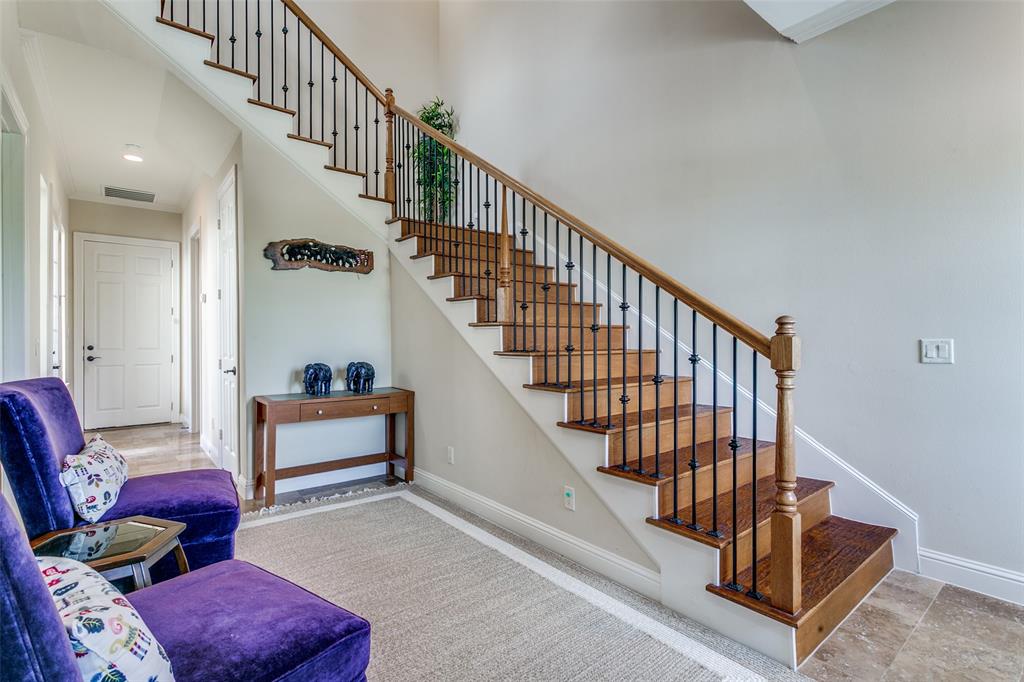 Bright foyer featuring a staircase that provides access to the home’s upstairs living spaces.