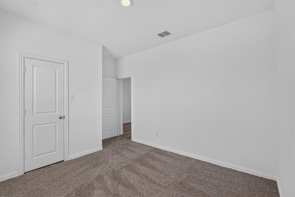 Spacious bedroom featuring neutral walls, recessed ceiling lighting, and soft carpet flooring