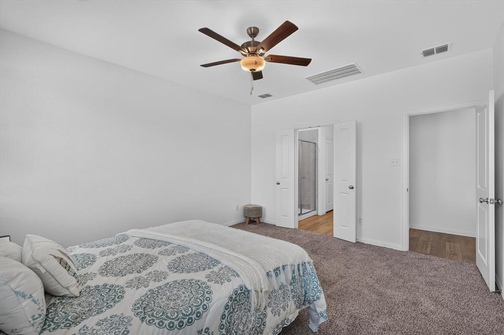 Carpeted bedroom with a ceiling fan