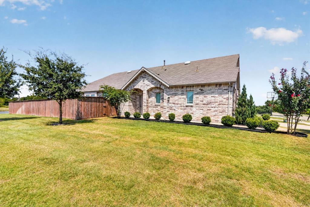 Stone exterior with pitched roof and multiple gable peaks, situated on expansive manicured lawn