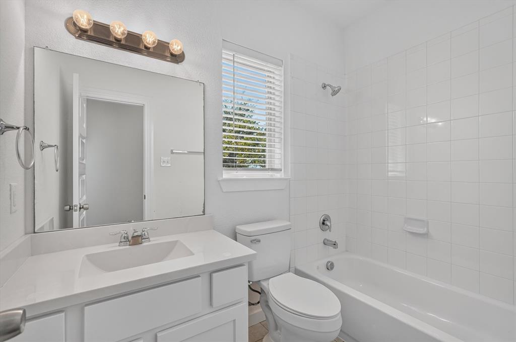Bright and clean bathroom featuring a large framed mirror, white subway tile walls, and a single-basin vanity with ample counter space