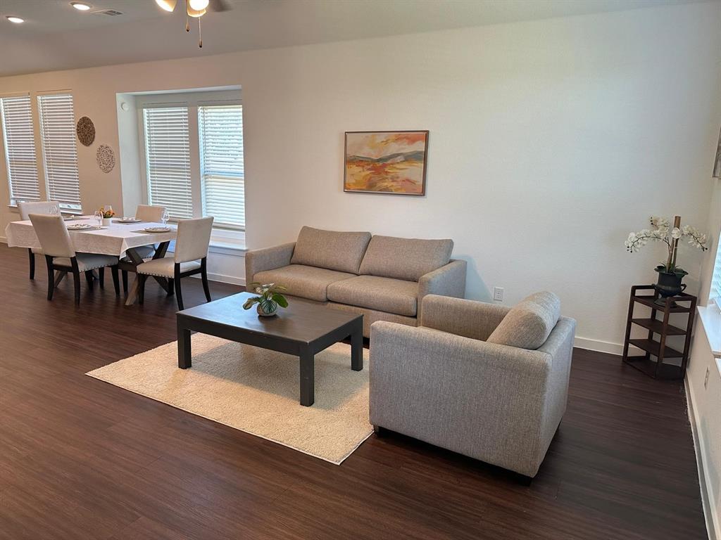 Open-concept living area with dark wood-finish flooring, recessed lighting, and a ceiling fan