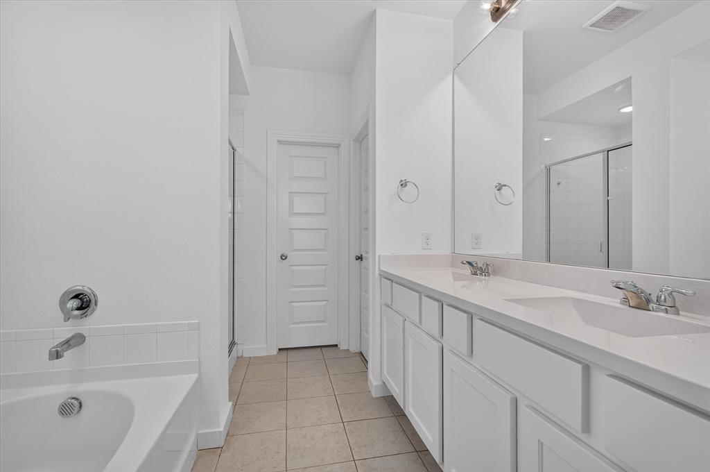 Spacious dual-vanity bathroom featuring a long countertop with integrated sinks, chrome fixtures, and ample mirror surface
