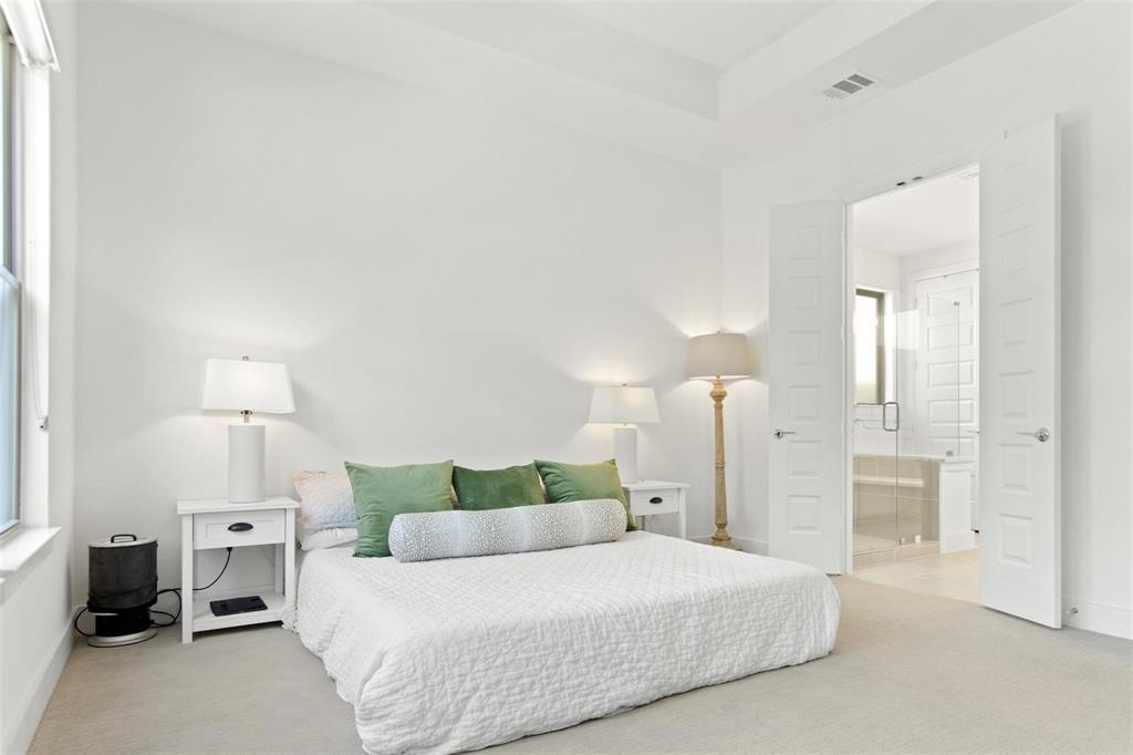 Spacious room with light-colored carpet flooring, high ceilings, and a large window