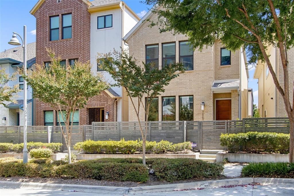 Contemporary two-story residence featuring a light brick facade and dark-framed windows