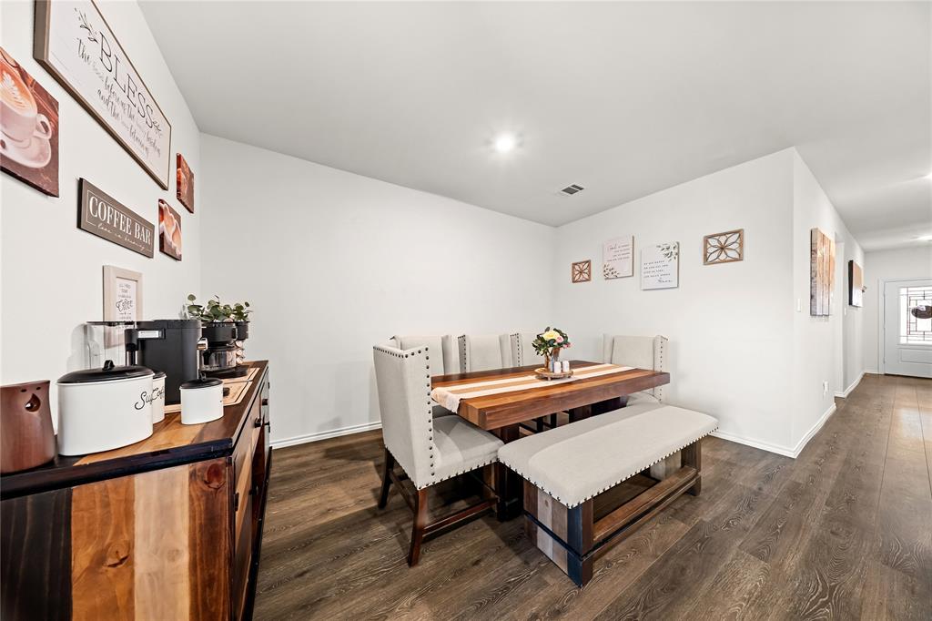Dining area featuring wood-finish flooring, recessed lighting, and a white interior door with decorative glass