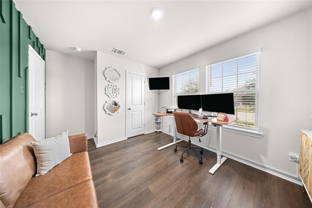 Versatile room featuring dark wood-finish flooring and a distinctive accent wall with vertical paneling
