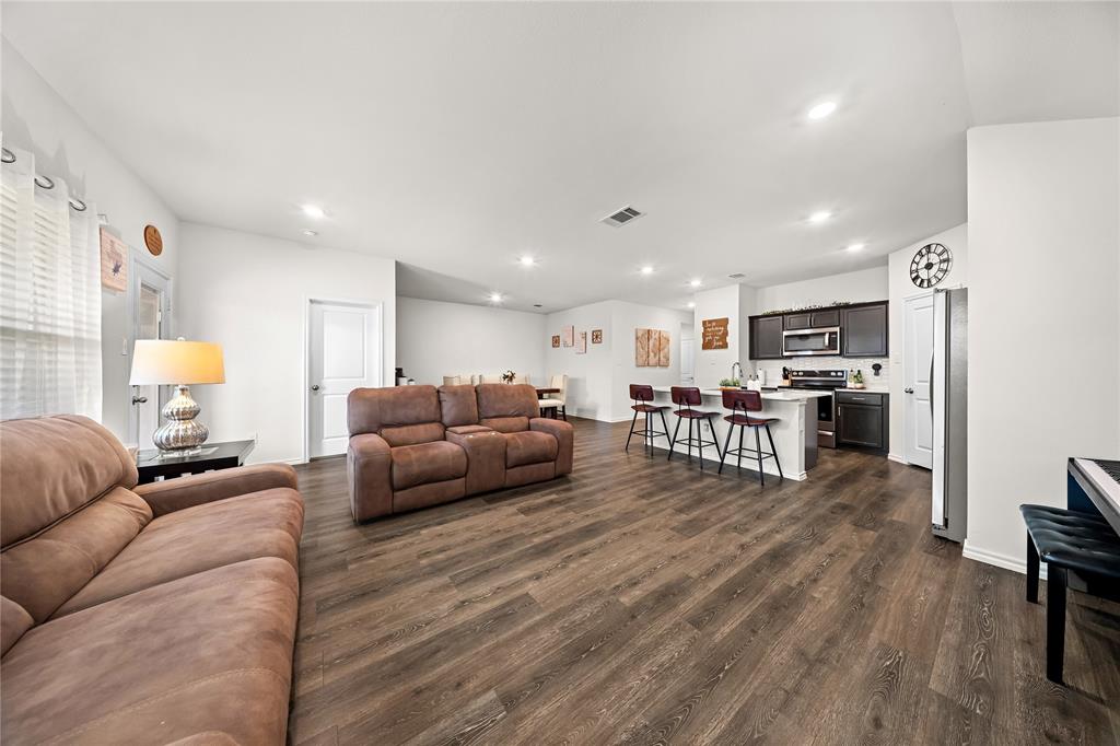Open-concept living space featuring wood-finish flooring, recessed lighting, and white walls