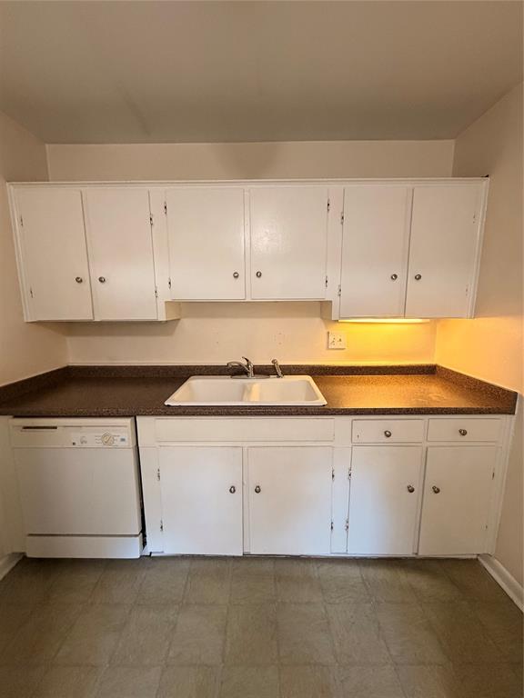 Kitchen featuring white cabinetry, solid-surface countertops, dual-basin sink with metallic faucet, and built-in dishwasher