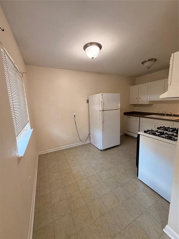 Kitchen featuring white cabinetry, a built-in gas range, a dishwasher, and tile flooring