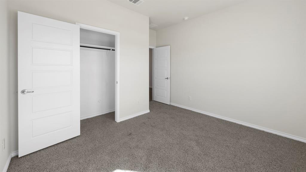 Carpeted room with white paneled doors, white baseboards, and neutral wall tones