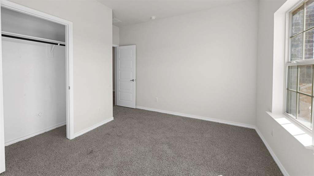 Carpeted room featuring a double-hung window, a built-in closet with a hanging rod, and a paneled interior door