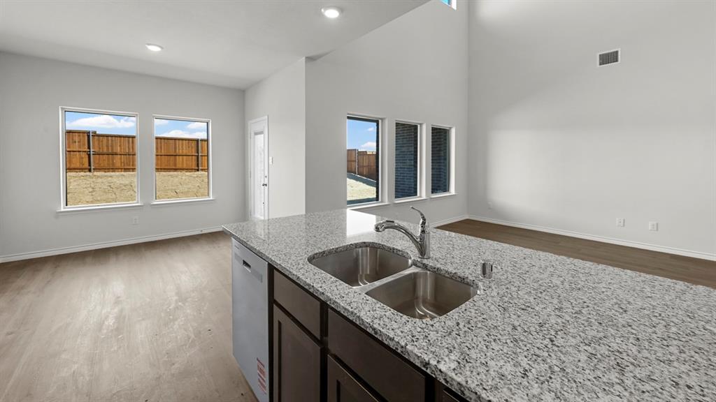 Kitchen island featuring a dual stainless steel sink and light granite countertop Kitchen island featuring a dual stainless steel sink and light granite countertop