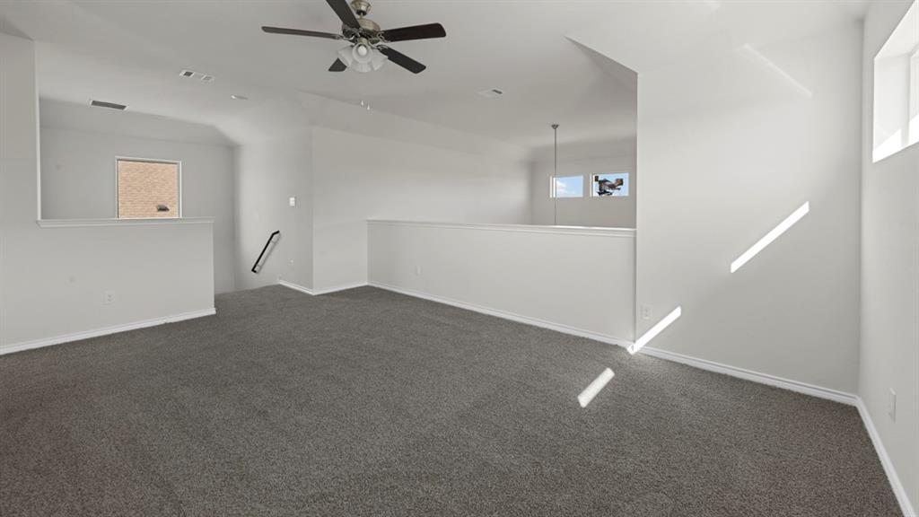 Open loft area featuring gray carpet flooring and white walls