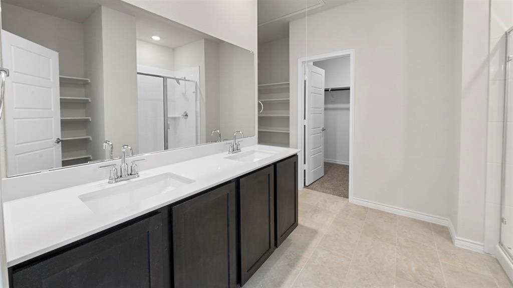 Bathroom featuring a dual vanity with dark wood-finish cabinetry, white countertop, and integrated sinks