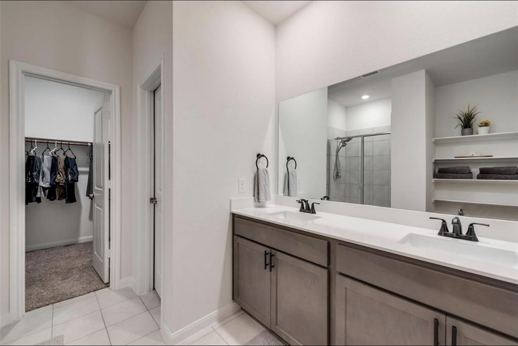Dual vanity with undermount sinks, stone-finish countertop, and matte black fixtures