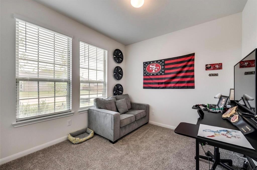 Versatile interior space featuring two windows with horizontal blinds, carpeted flooring, and a ceiling-mounted light fixture