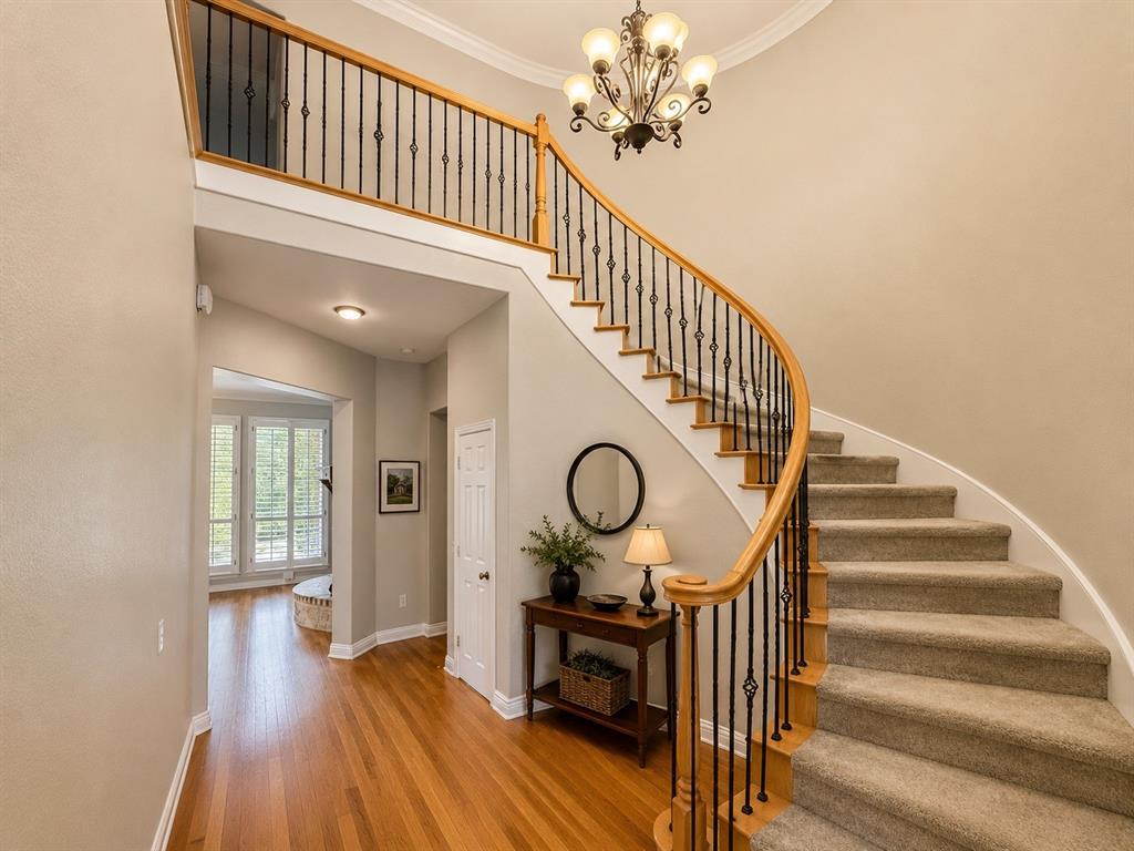 Curved staircase with carpeted treads and wrought iron balusters