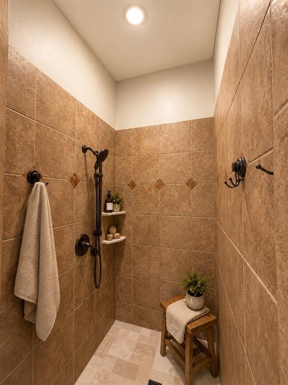 Tiled shower stall featuring bronze fixtures and an integrated shower niche