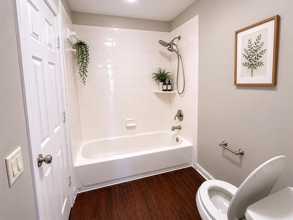 White subway tile shower surround with a built-in corner shelf and brushed nickel fixtures