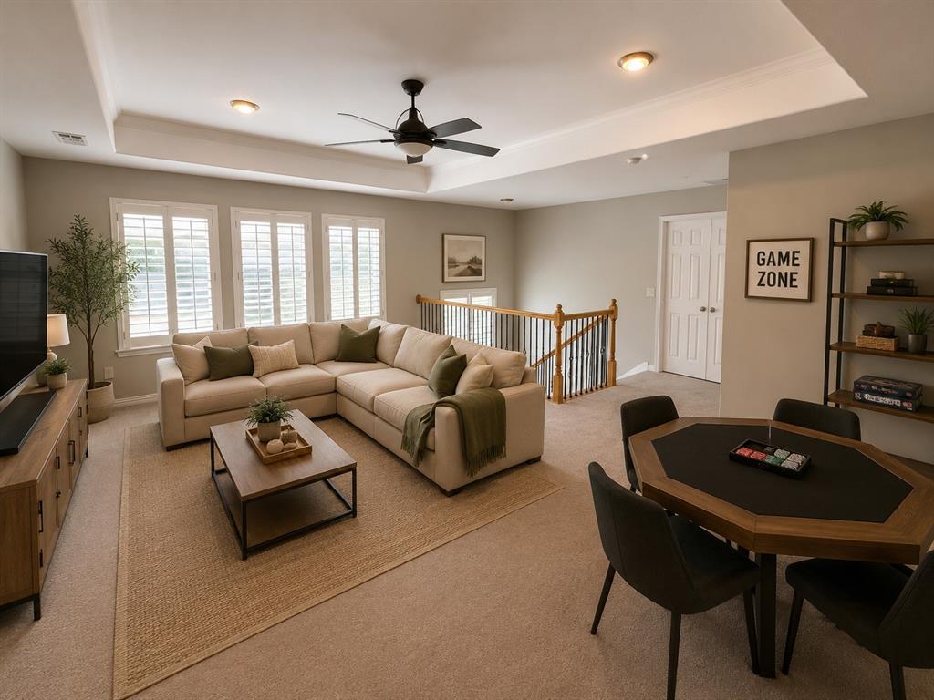 Spacious upper-level room featuring a tray ceiling, recessed lighting, and a ceiling fan