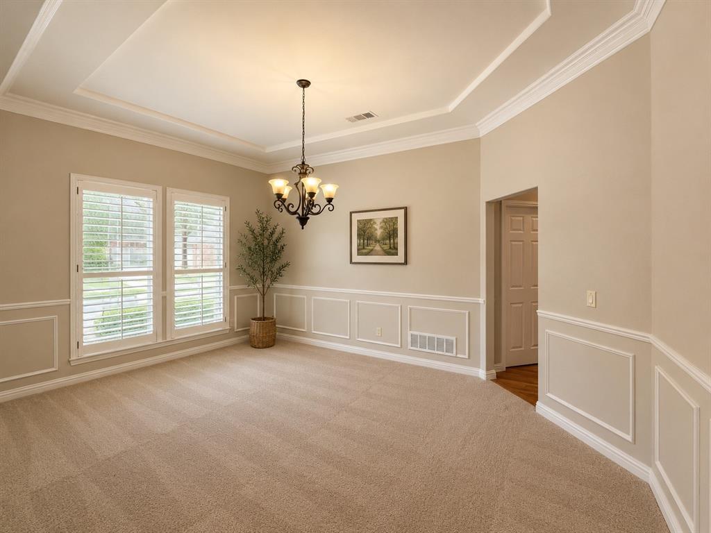 Spacious room with a tray ceiling and crown molding
