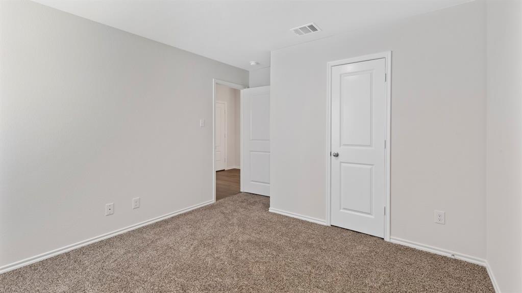 Carpeted room with light neutral walls and white trim