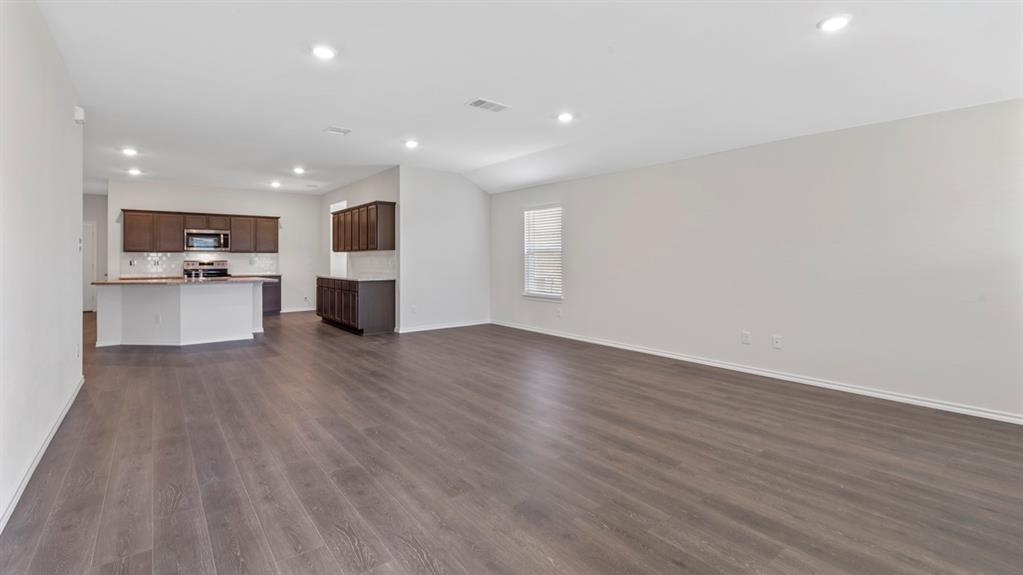 Open-concept living area with wood-finish flooring and recessed lighting