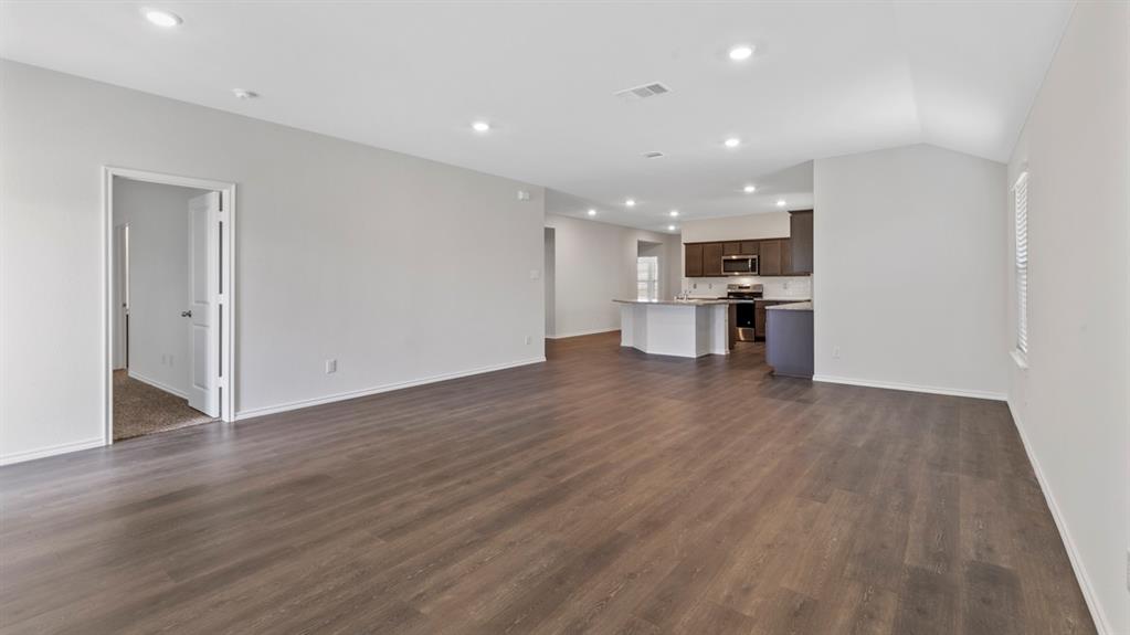 Spacious open-concept living area featuring wood-finish flooring, recessed lighting, and light neutral wall tones