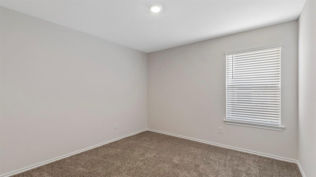 Neutral-toned room featuring a single window with blinds, recessed ceiling lighting, light gray walls, and brown carpet flooring