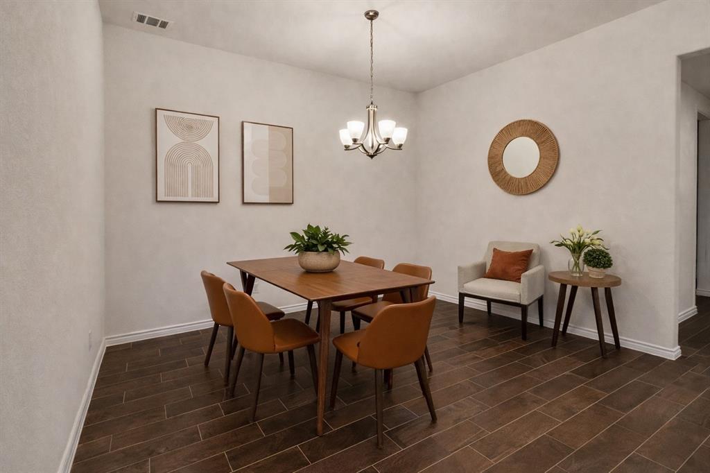 Dining area featuring wood-finish flooring, white baseboards, and a chandelier light fixture