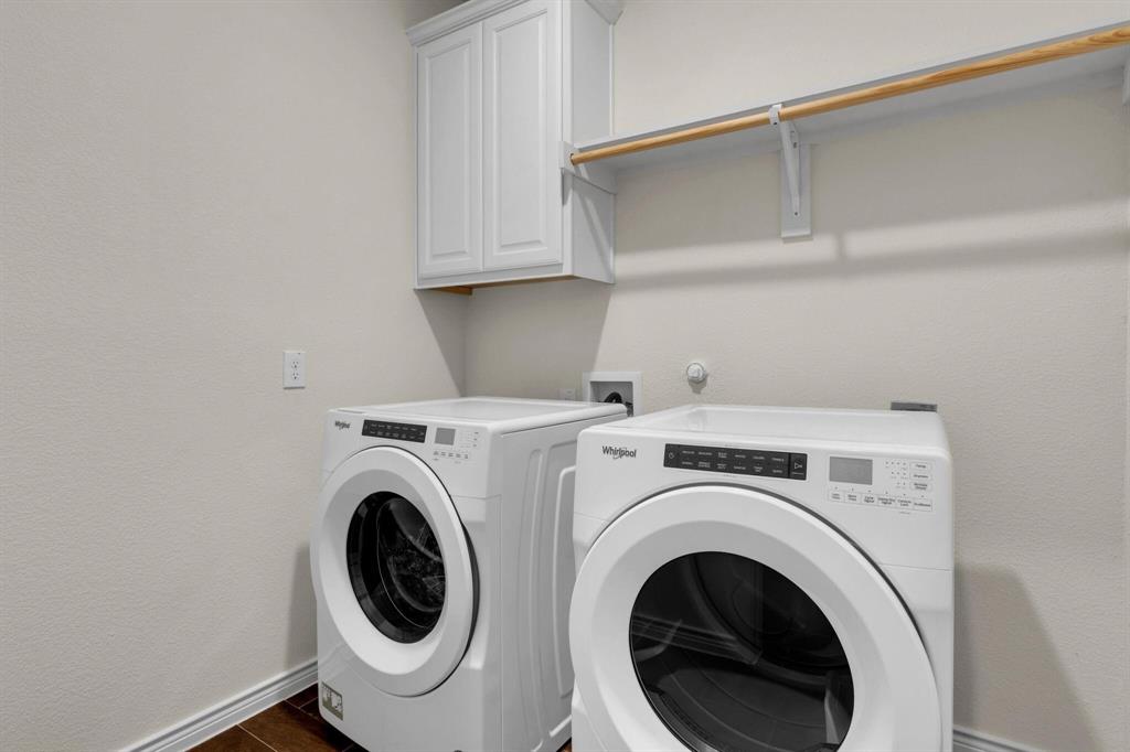 Dedicated laundry space featuring wood-finish flooring and a neutral wall color
