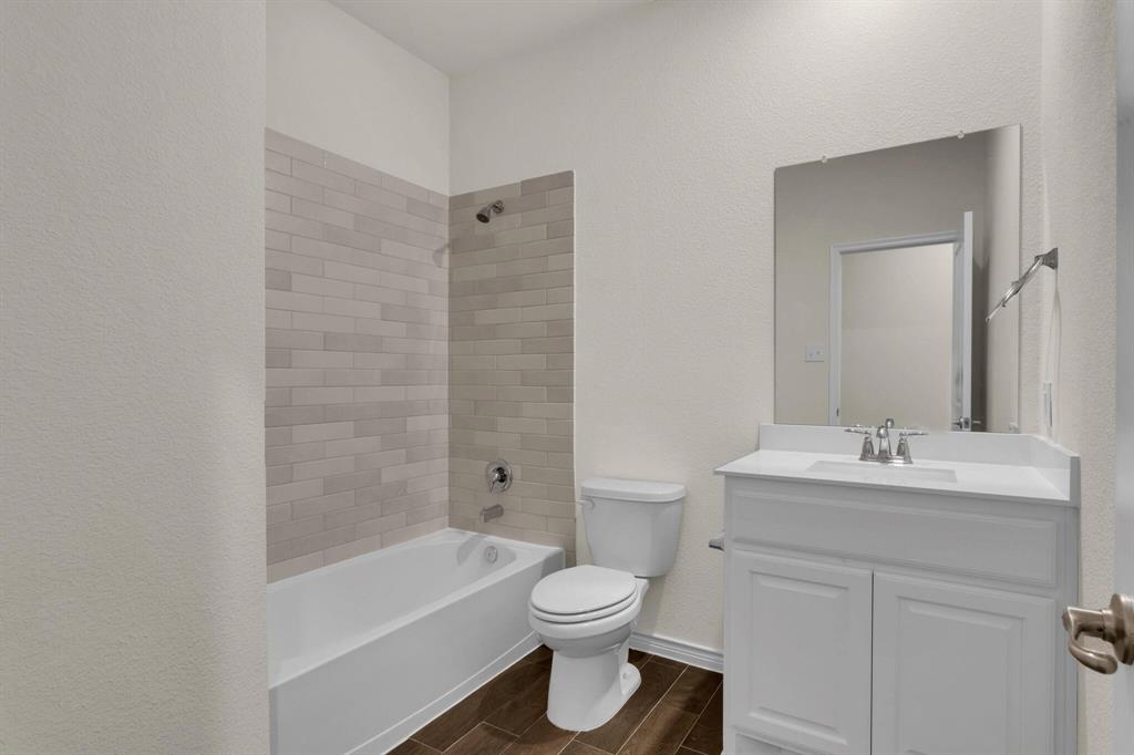 Bathroom featuring a white vanity with a single sink, an integrated white countertop, and a large wall-mounted mirror