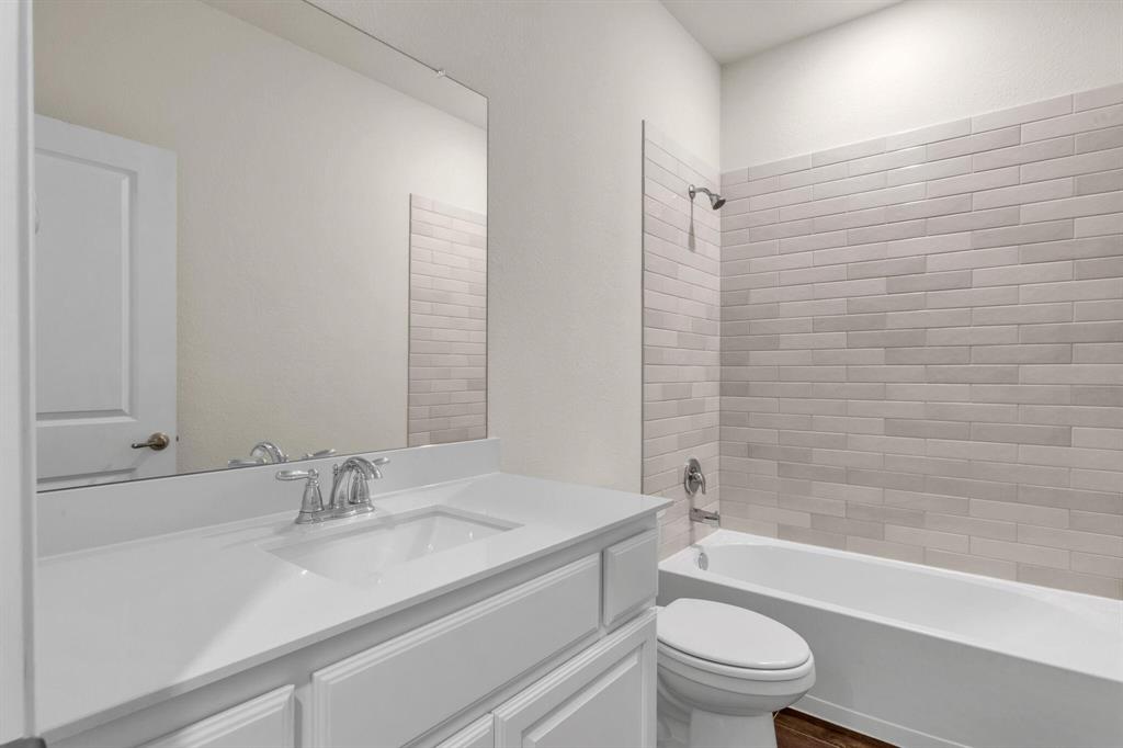 Bathroom featuring a white vanity with an integrated sink, polished chrome faucet, and a large wall-mounted mirror