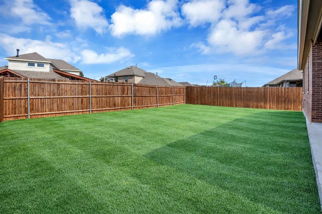 Expansive green lawn with a defined perimeter fence