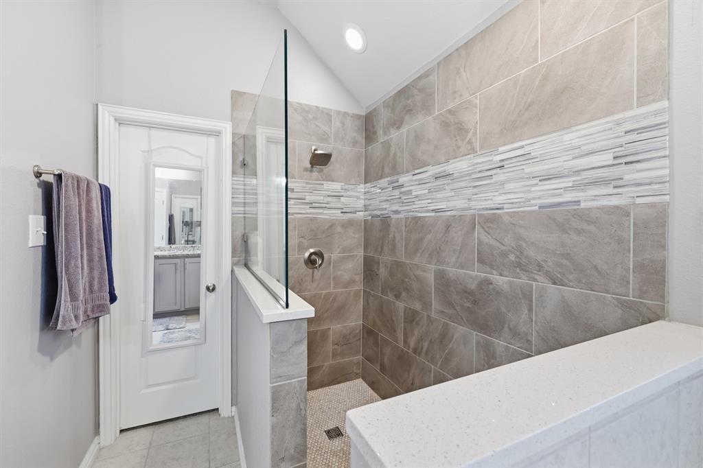 Walk-in shower featuring a frameless glass panel