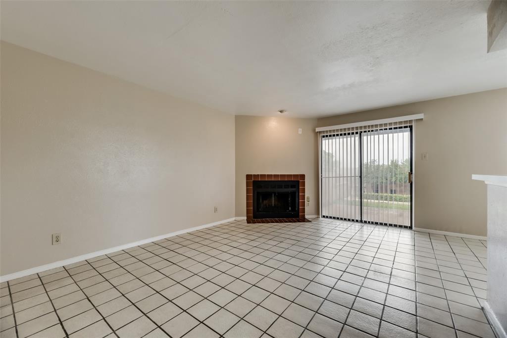 Unfurnished living room with a tile fireplace and light tile floors