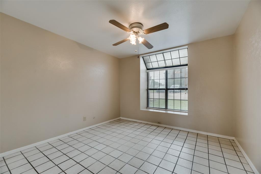 Tiled empty room featuring ceiling fan