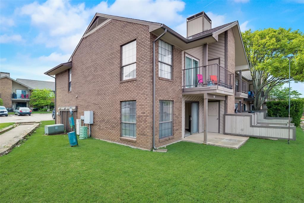 Back of house featuring a balcony and a lawn