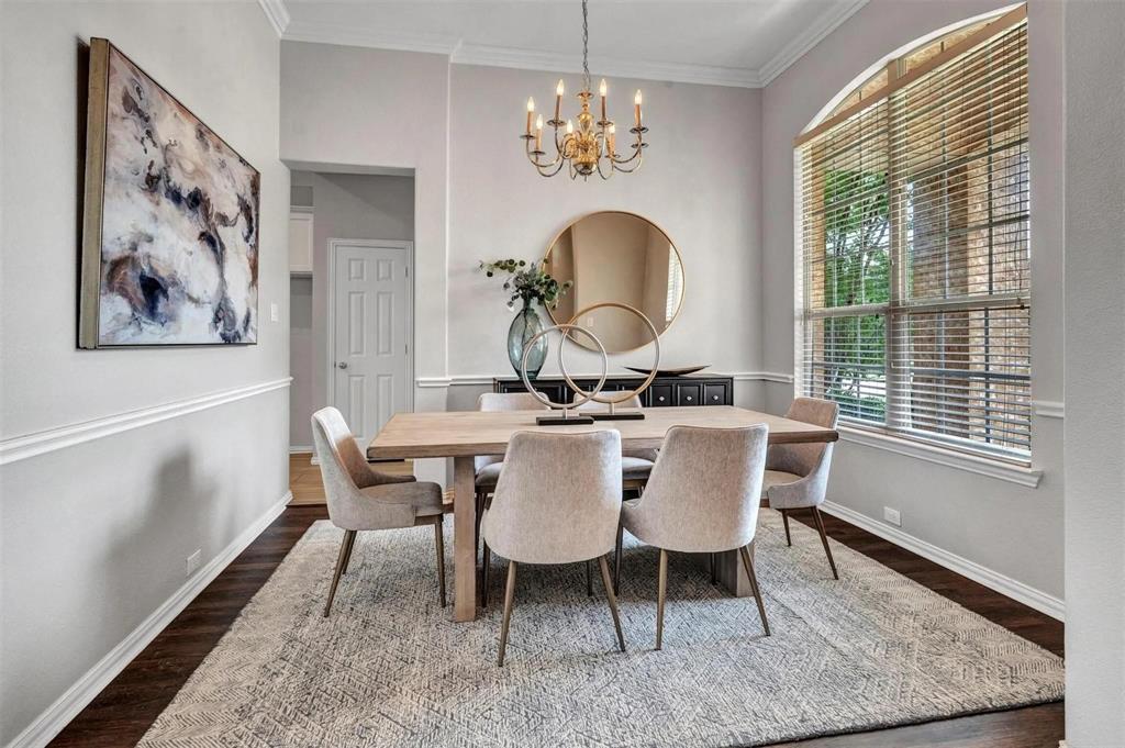 Dark wood-finish flooring with crisp white baseboards and chair rail molding